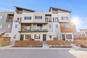 View of front facade with stucco siding, a fenced front yard, and a balcony