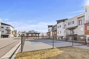 View of basketball court featuring a tennis court and a residential view