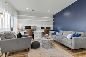 Living area featuring light wood finished floors, built in study area, and recessed lighting