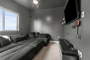 Home theater room featuring light carpet and ceiling fan