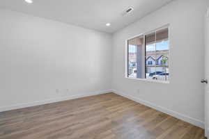Spare room featuring light wood-type flooring and recessed lighting