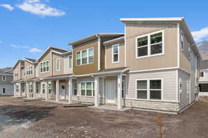 View of front of home featuring stone siding, a residential view, and board and batten siding