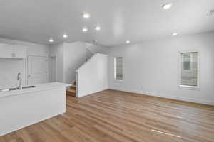 Unfurnished living room with light wood-style flooring and recessed lighting