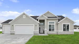 View of front of home featuring a front lawn, driveway, and stucco siding