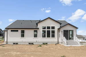 Rear view of property with roof with shingles, stucco siding, and entry steps