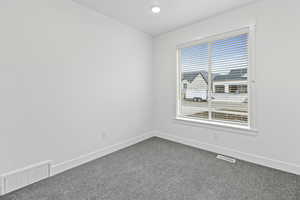 Carpeted empty room featuring baseboards