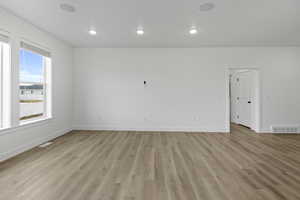 Empty room featuring light wood-style flooring and recessed lighting