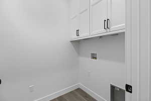 Laundry area featuring cabinet space, dark wood-style flooring, and washer hookup