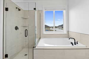 Bathroom featuring a garden tub and a shower stall
