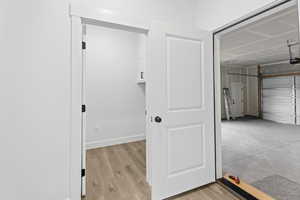 Laundry room with a garage and light wood finished floors
