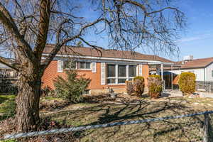 View of front of property featuring brick siding and a sunroom