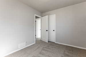 Unfurnished bedroom with carpet flooring and baseboards