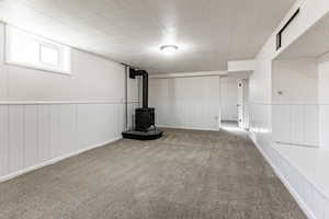 Basement with carpet and a wood stove