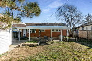 Rear view of property with a patio, brick siding, and a garden