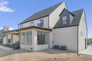 Back of house featuring a shingled roof and a patio area