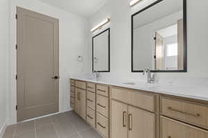Full bath with double vanity and light tile patterned flooring