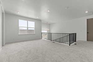 Unfurnished room featuring a chandelier and light colored carpet