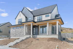 Modern farmhouse style home featuring a porch and stone siding
