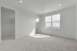 Spare room featuring light colored carpet and recessed lighting