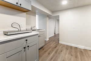 Laundry room featuring light wood-style flooring and a textured ceiling
