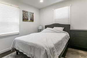 Bedroom with dark wood-style flooring and recessed lighting