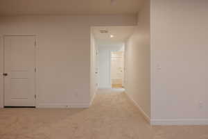 Corridor featuring light colored carpet and recessed lighting