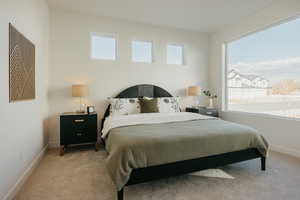 Bedroom with baseboards and light carpet