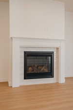 Detailed view of wood finished floors and a glass covered fireplace