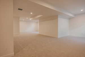 Finished below grade area featuring recessed lighting and light colored carpet