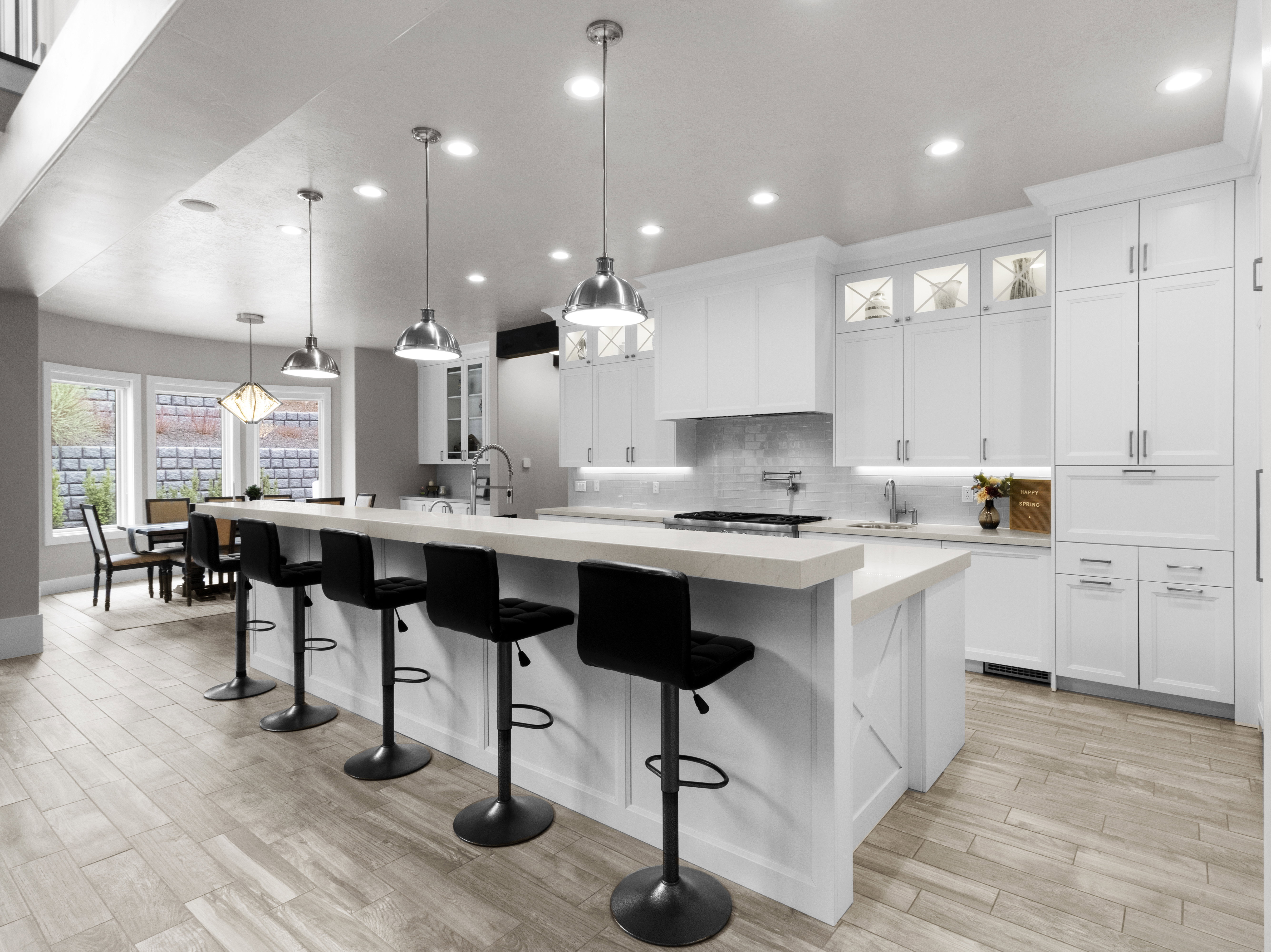 Kitchen featuring glass insert cabinets, light wood-style flooring, and hanging light fixtures
