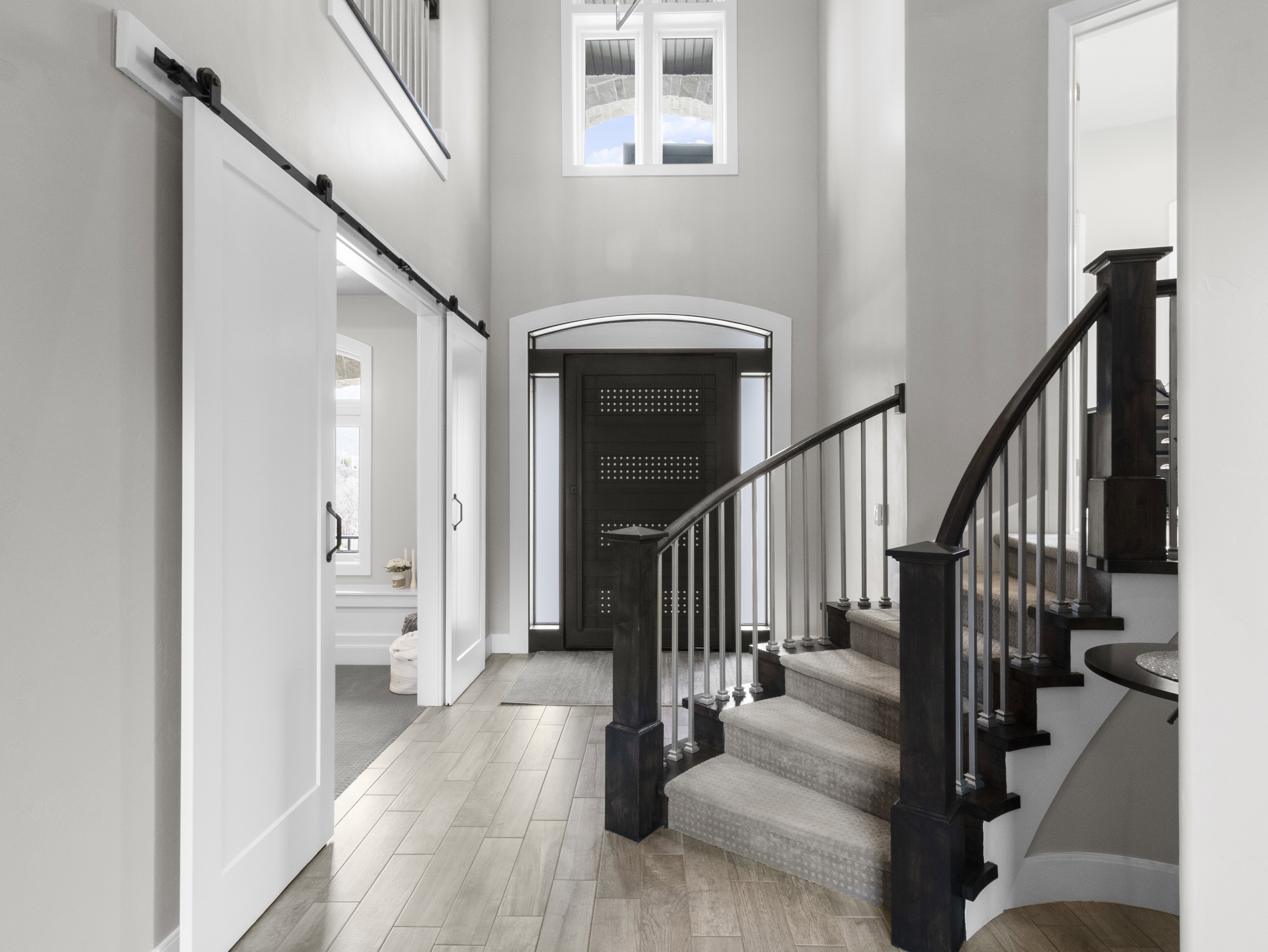 Entryway featuring a barn door, a high ceiling, and wood tiled floors