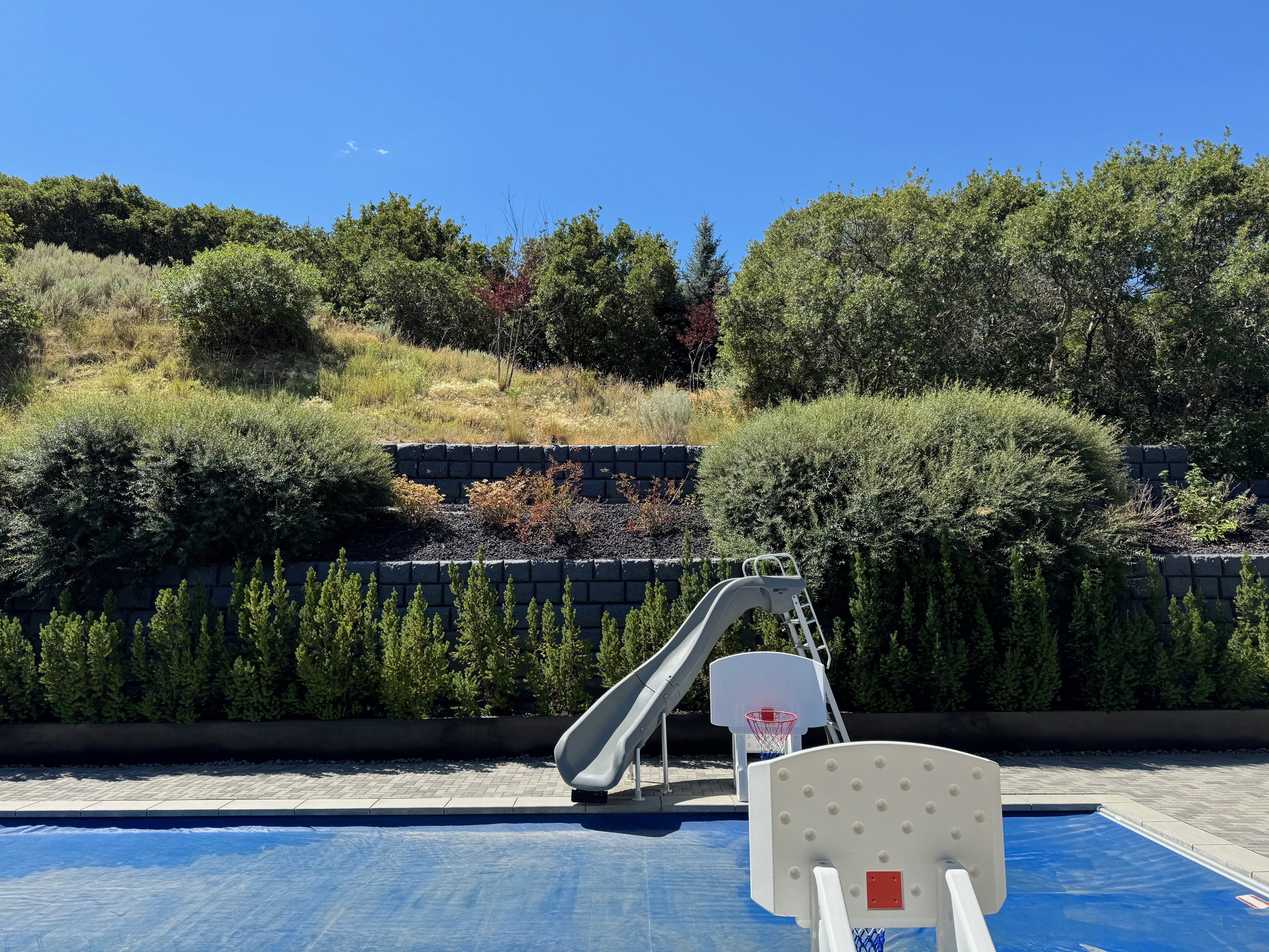 View of pool featuring a water slide and patio surround