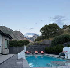View of swimming pool with patio surround, a fenced backyard, and a mountain view