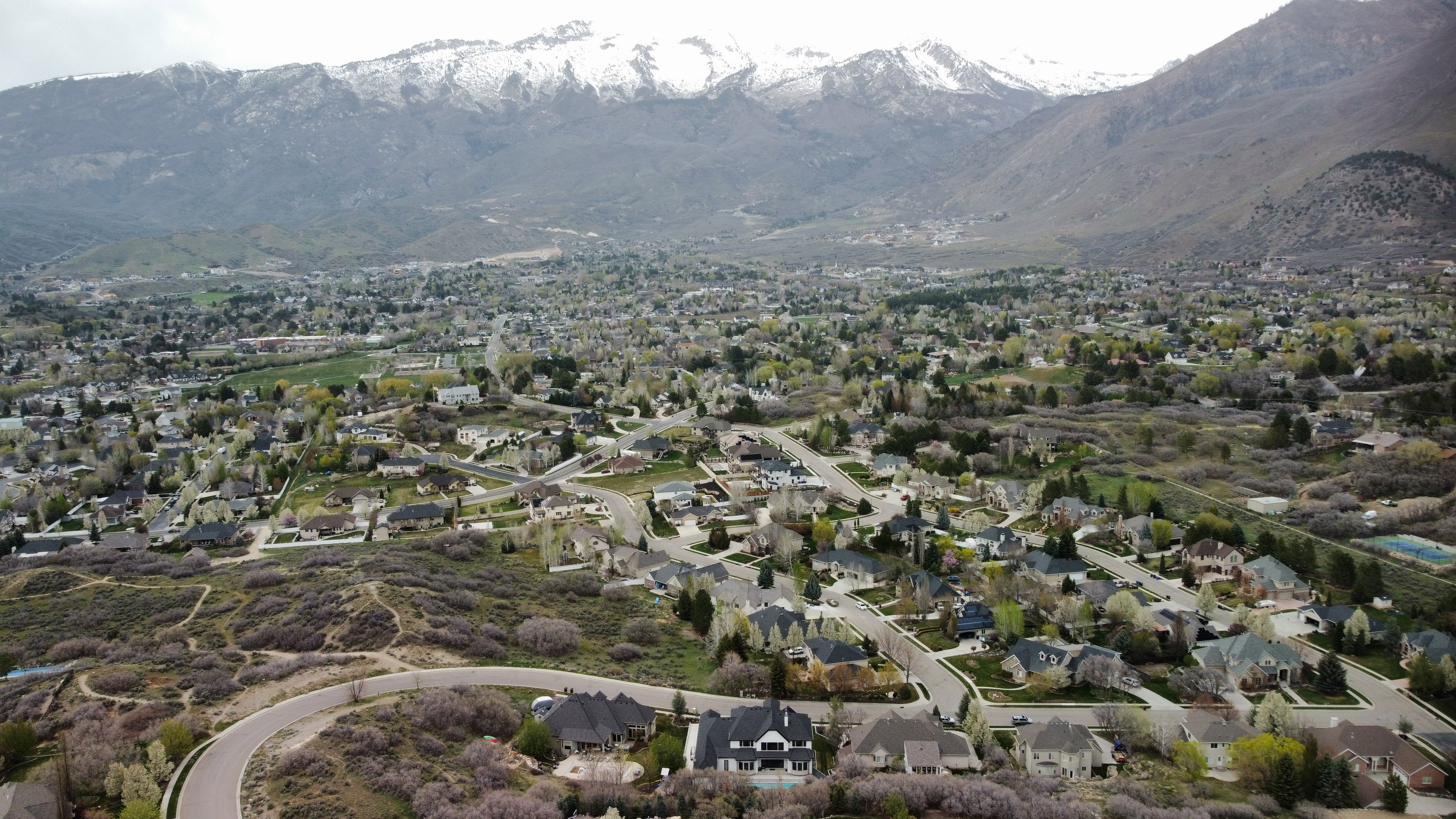 Aerial overview of property's location with nearby suburban area and a mountainous background