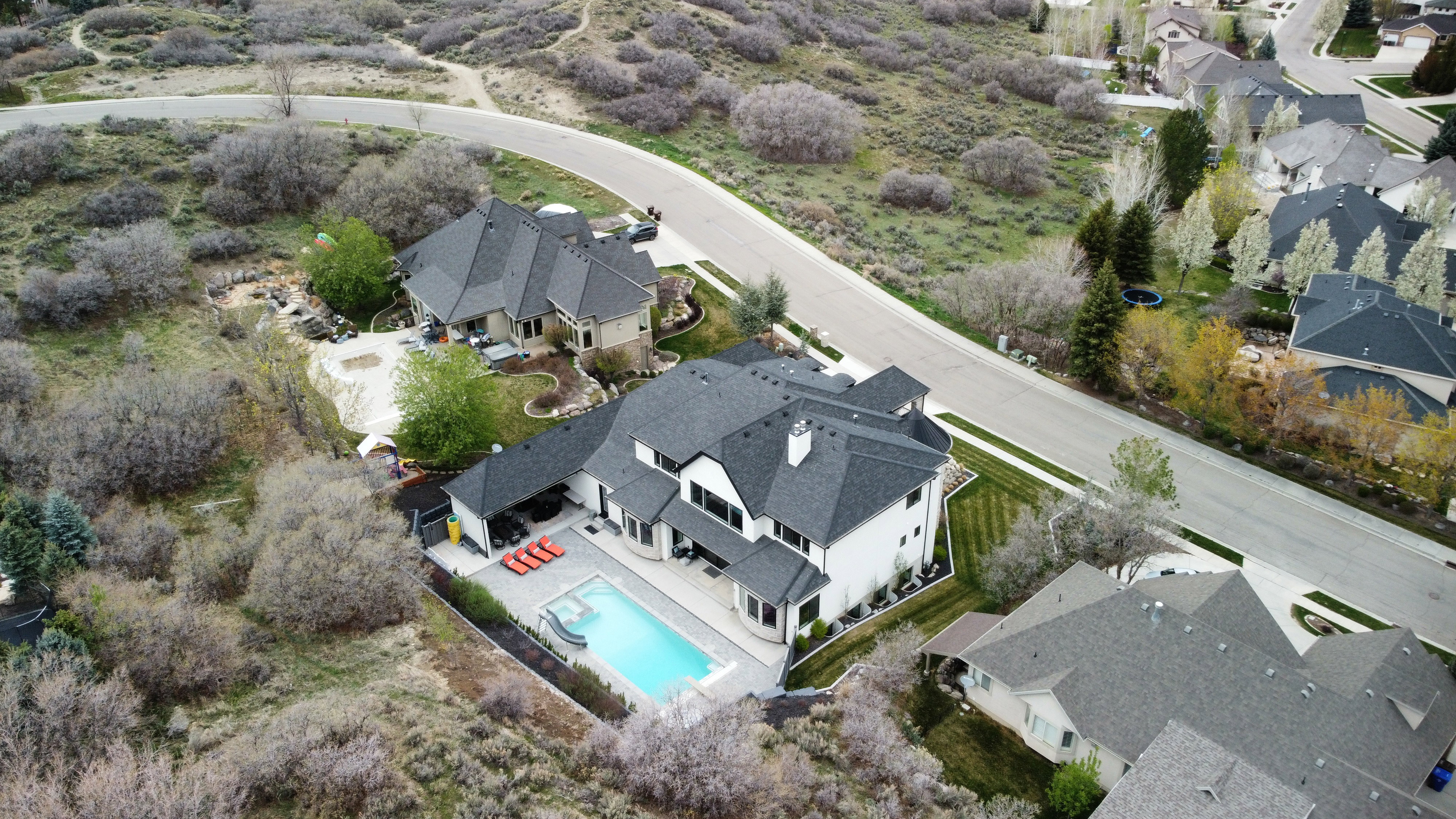 Aerial overview of property's location with nearby suburban area and a pool