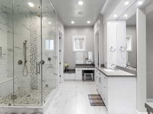 Full bath with vanity, a marble finish shower, recessed lighting, and light marble finish flooring