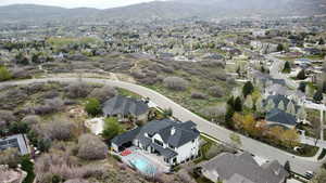 Aerial view of property and surrounding area with a mountainous background and nearby suburban area