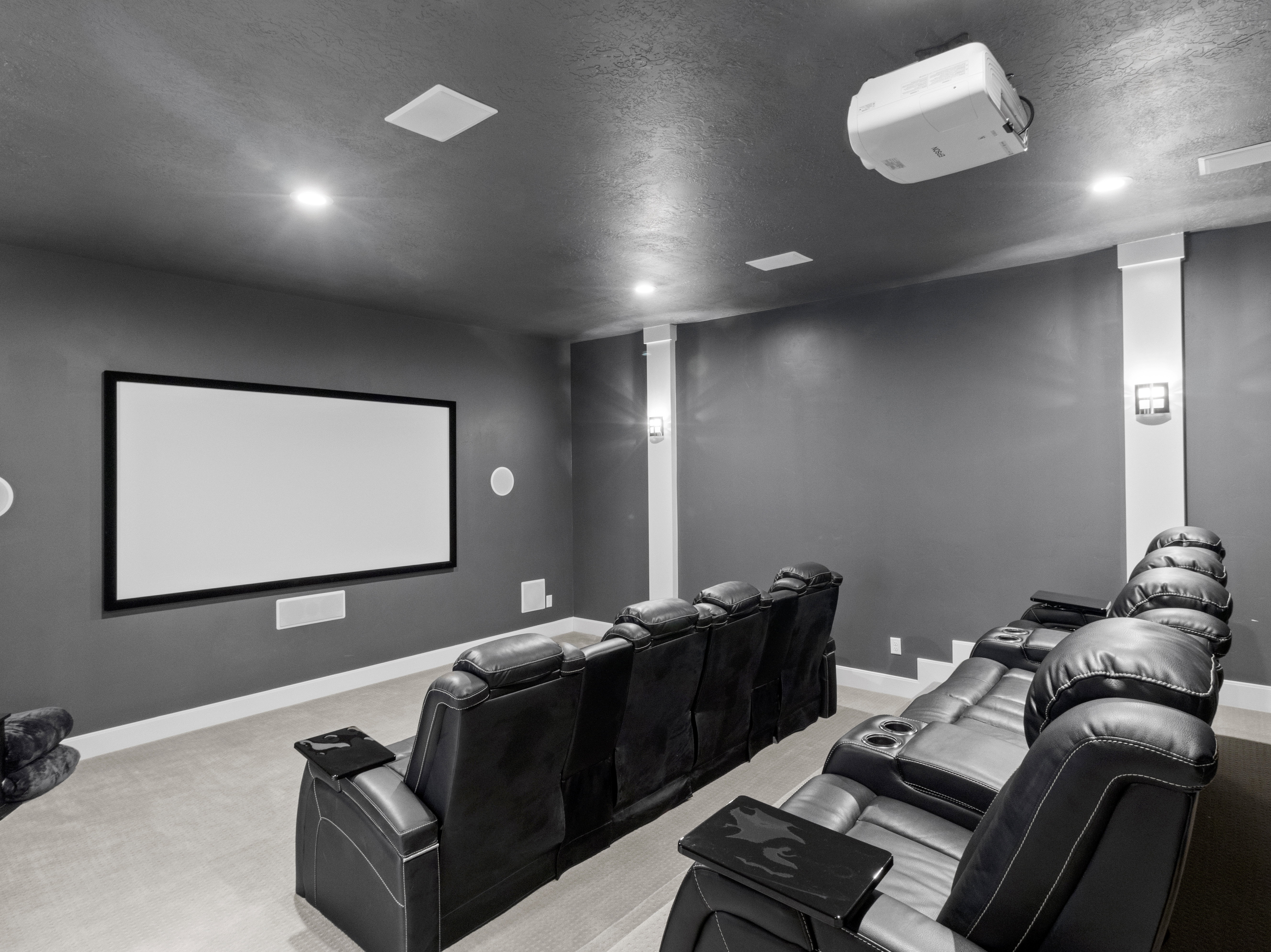 Cinema room with light colored carpet and a textured ceiling