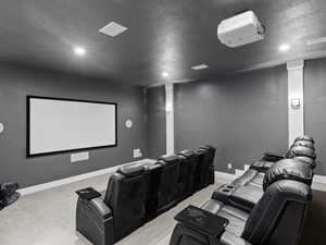 Cinema room with light colored carpet and a textured ceiling