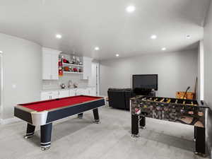 Recreation room featuring light colored carpet, bar with sink, recessed lighting, and pool table