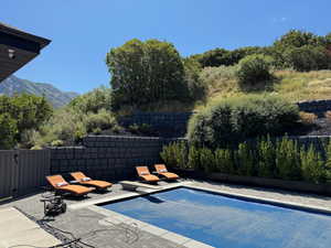 View of pool with a fenced backyard, patio surround, and a mountain view