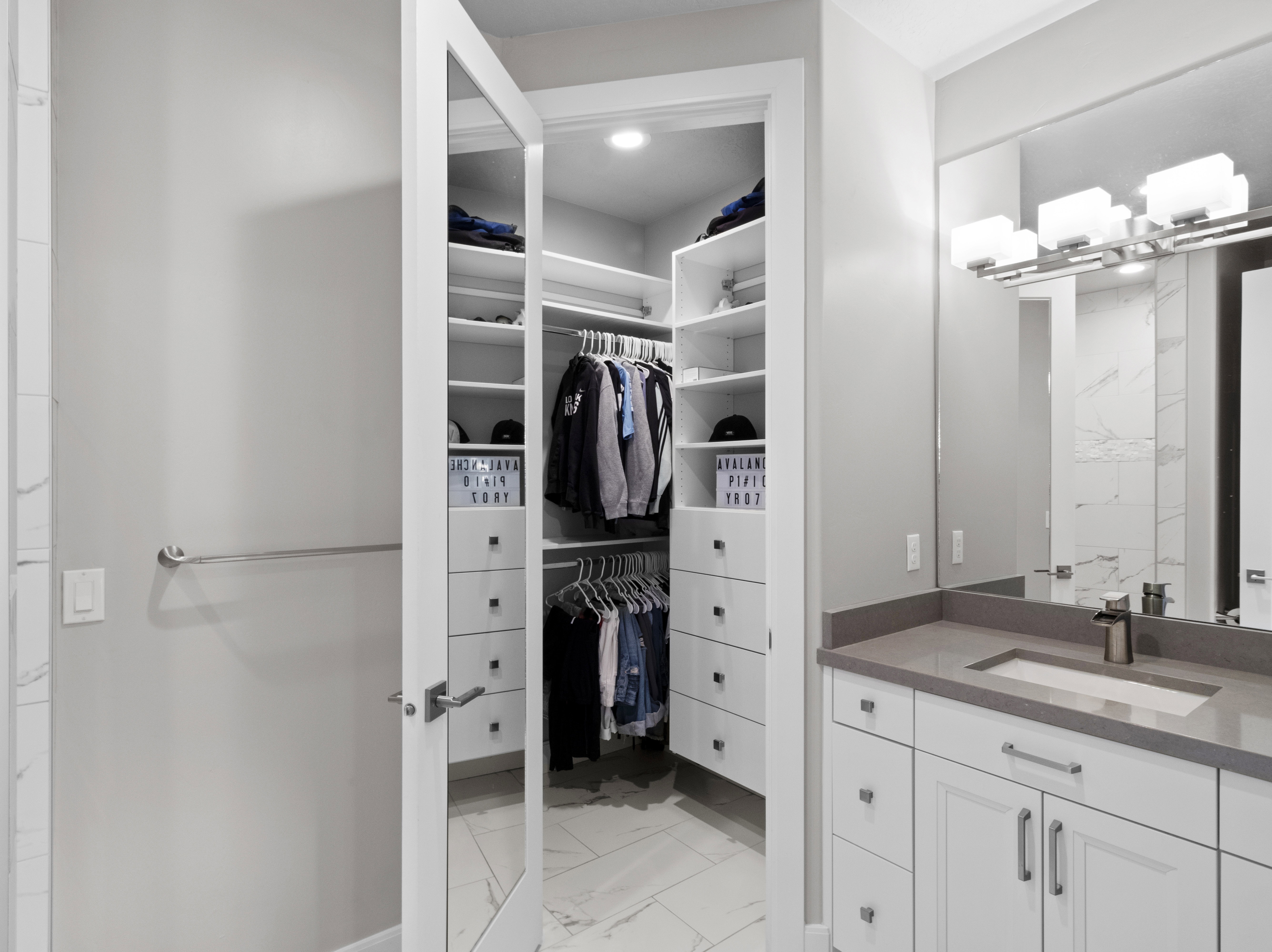 Bathroom with light marble finish flooring, vanity, and a spacious closet