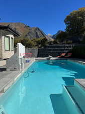 View of pool featuring a fenced backyard, a mountain view, and patio surround
