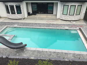 Swimming pool featuring a patio and a water slide