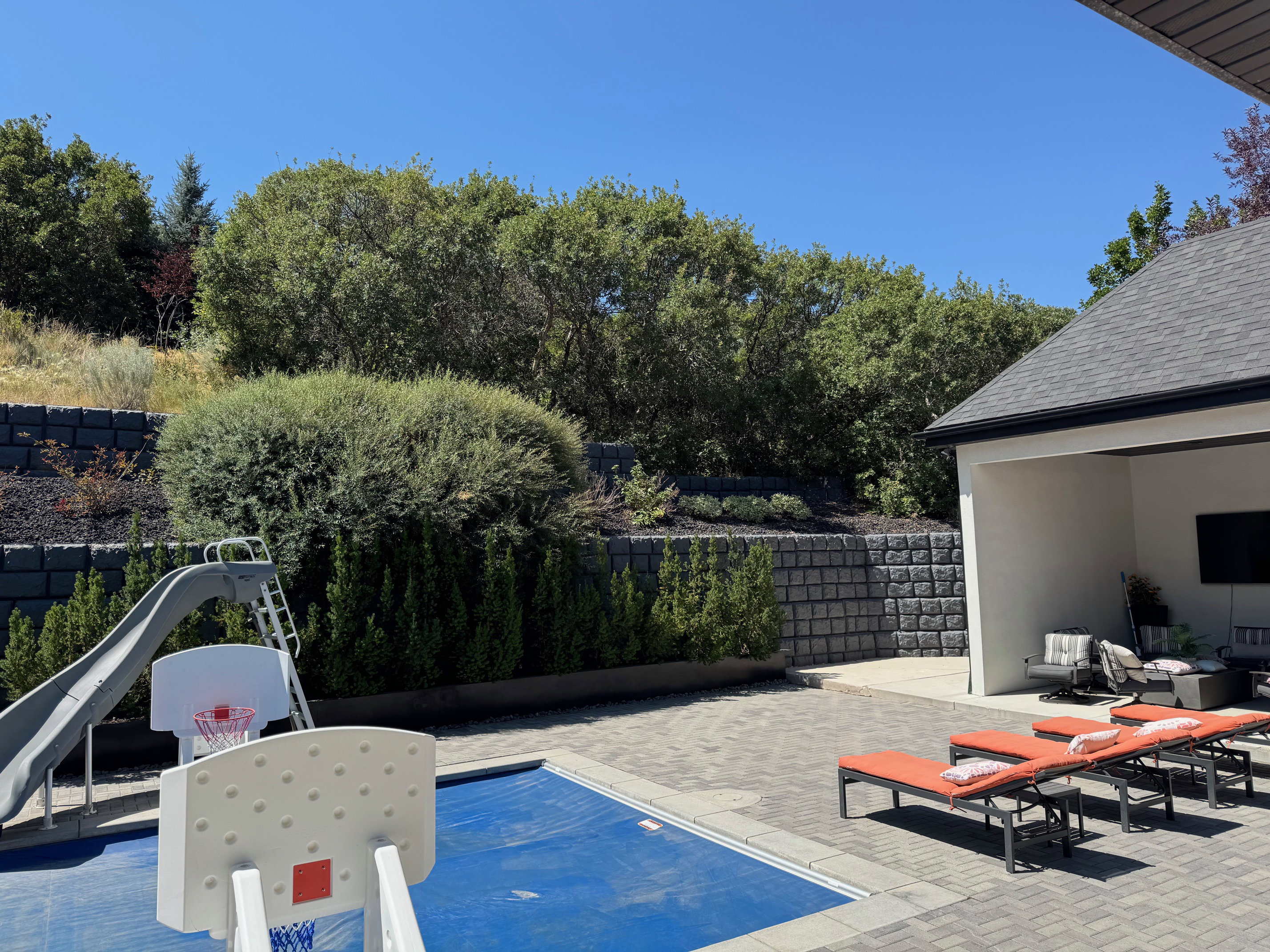View of swimming pool with patio surround, a water slide, and outdoor lounge area