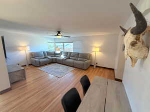 Living area featuring a ceiling fan and light wood-type flooring