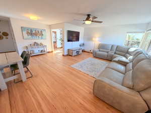 Living room featuring light wood-style flooring and ceiling fan