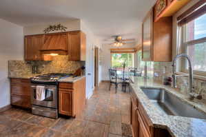 Looking into dining area with ceiling fan, and tasteful backsplash