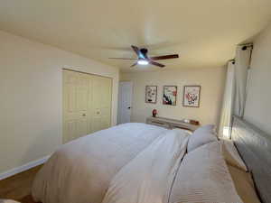 Carpeted bedroom featuring a closet and a ceiling fan