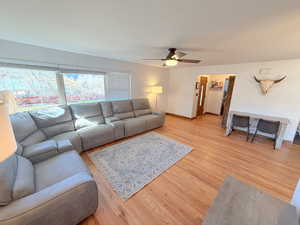 Living area featuring light wood finished floors and a ceiling fan